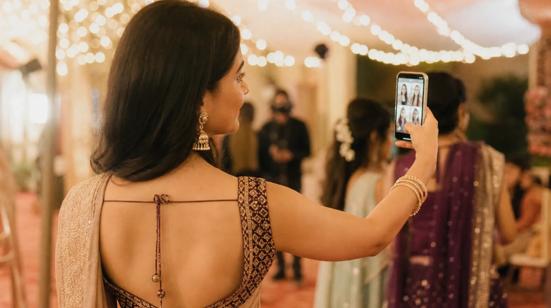 A wedding guest taking a selfie as a grid of her matched photos appears on her phone, venue lights behind.